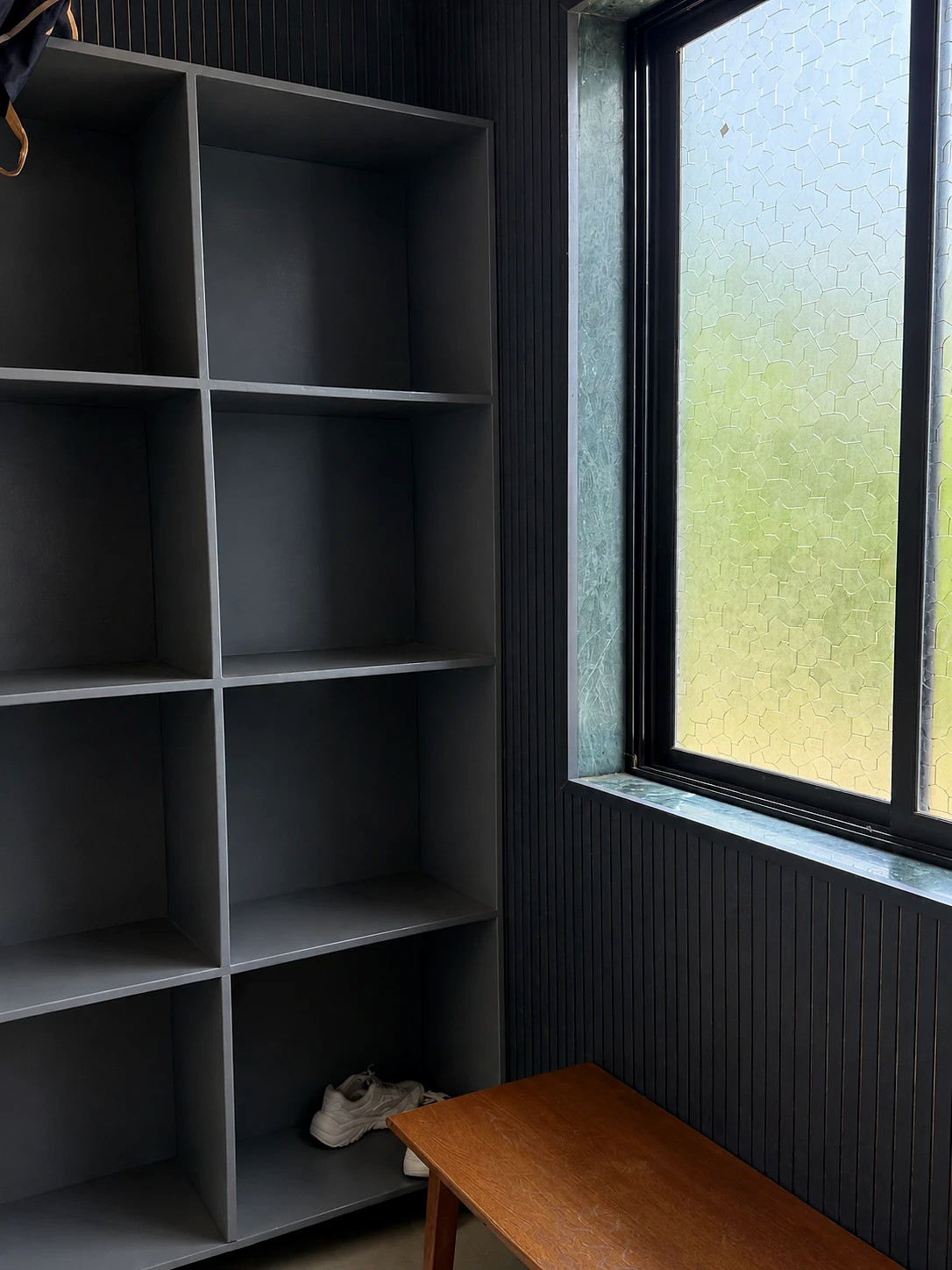 The changing room: open storage cubbies and a wooden bench beside a frosted window