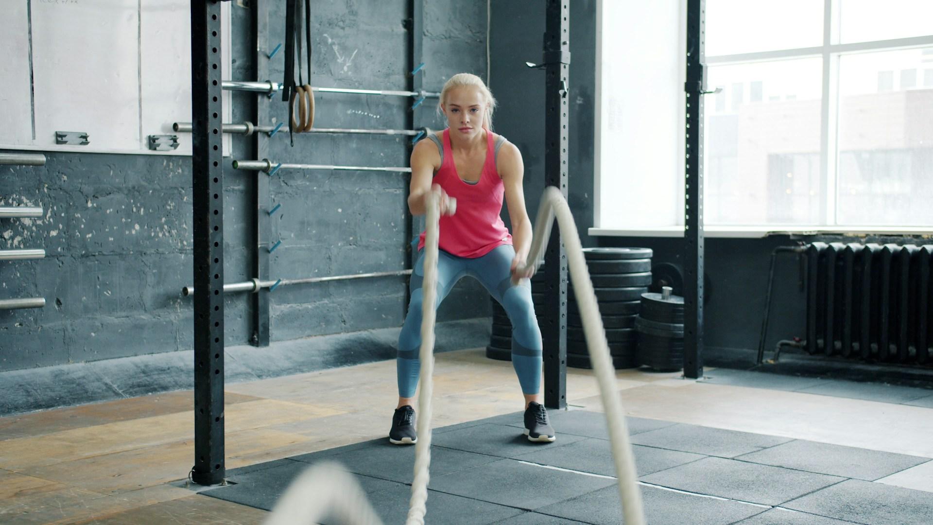 A person training with battle ropes in a gym